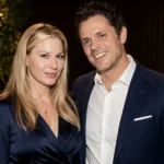 Melanie Lynn Clapp standing with a man in an elegant indoor portrait with stylish formal clothing.
