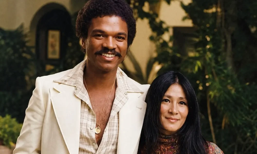 Teruko Nakagami in a vintage-style portrait standing beside a smiling man outdoors